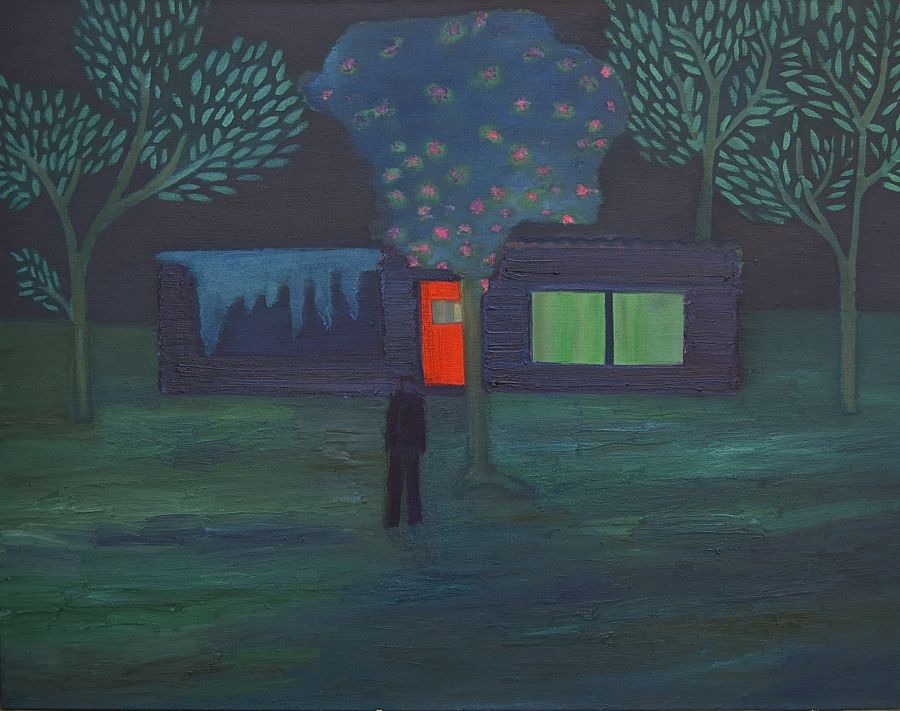 A figure standing amongst trees outside a house at night.