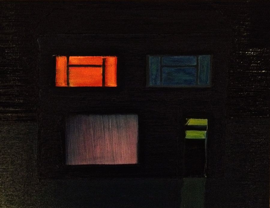 A house at night with colourful windows.