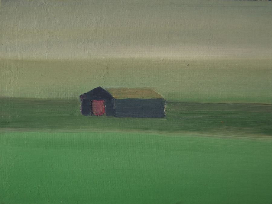 A barn in a green field.