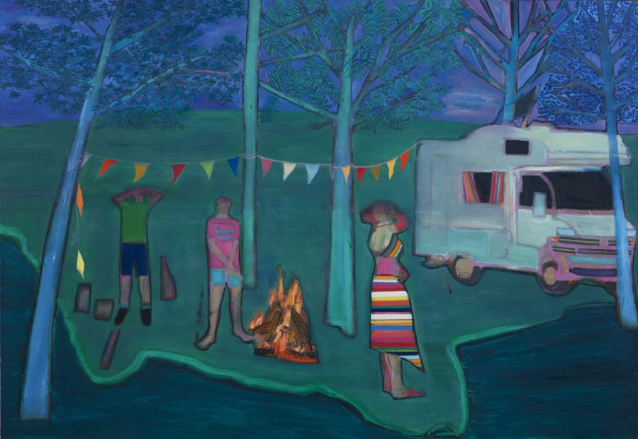 Three figures and a fire next to their camping van on the edge of water at night.