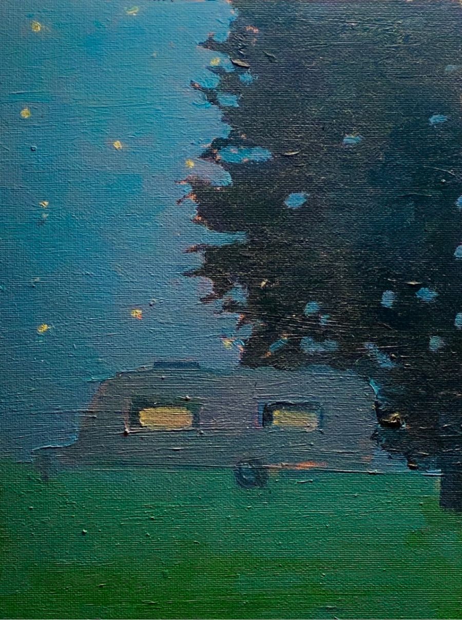 A caravan under the stars next to a tree.
