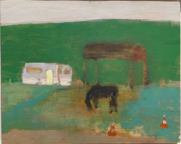 A horse grazing in front of a caravan and wooden structure with a green hill behind..